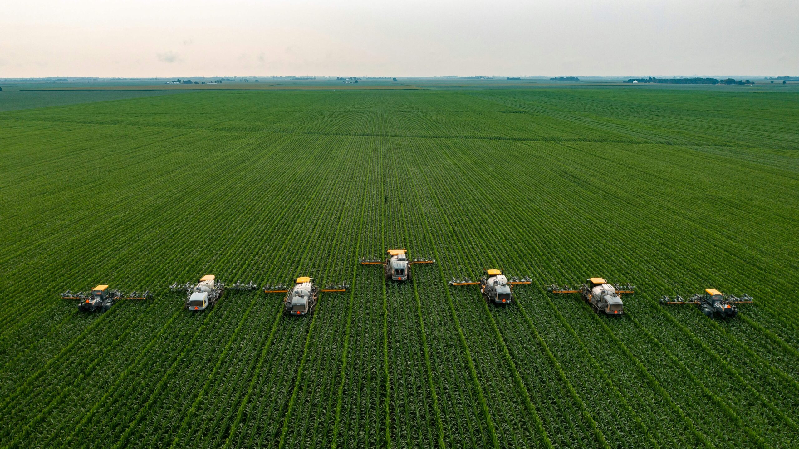 Aerial view of crop sprayers working across a green farm field